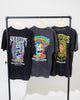 Three unisex SourStrips Sour Storm Tees hang on a rack, each featuring vibrant artwork. The back of these cotton graphic T-shirts displays "Sour Strips" and the slogan "Sour Candy to Die For.