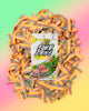 A Melonade-Six Pack from SourStrips sits on a pile of vibrant, sugar-coated candy strips, capturing the bold energy of Sour Summer Duos with a striking pink, yellow, and green gradient backdrop.