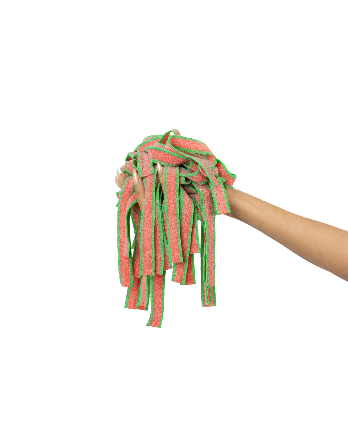 A hand holding a bunch of red and green gummy candy strips against a gradient background that fades from green to peach.