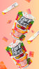 Sour Strips Bites-Four Pack candy in colorful packaging pops against a peach gradient backdrop. Strawberry strips, both loose and spilling from open packets, showcase vibrant red and yellow hues that embody the extreme sour flavor of every Sour Strips bite.