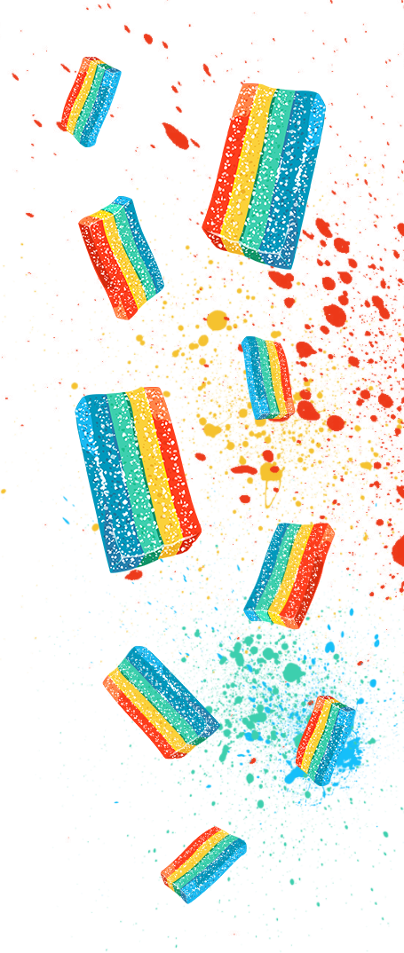 Colorful rectangular candies with rainbow stripes appear to be exploding or bursting mid-air, scattering red, yellow, and blue powder or fragments against a white background. The vibrant display creates a dynamic and playful visual effect.