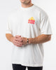 A person wearing the "Sunshine Tee" by SourStrips, which features a sun graphic on the chest and "Sour Strips" text, stands against a plain white background. The unisex design boasts an oversized box fit, with the person's hands loosely clasped in front while their face remains out of frame.